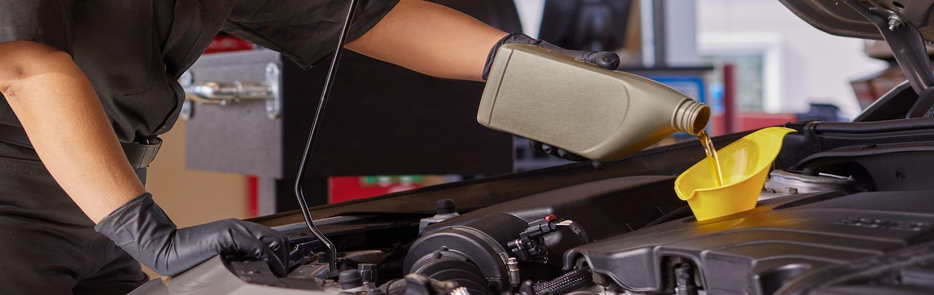 Technician pouring fresh motor oil